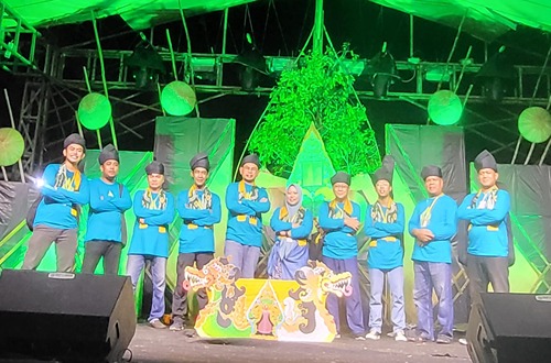 Tim Kesenian Kotabaru berpose di atas panggung dengan latar hijau setelah tampil di Aruh Sastra Kalimantan Selatan ke-21.