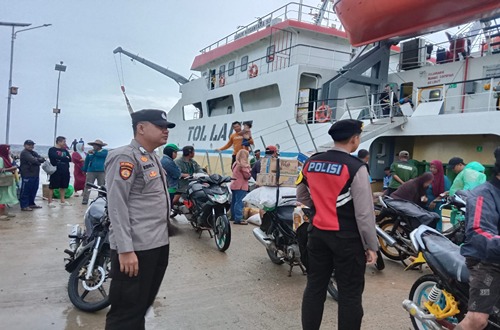 Pengamanan Maksimal: Polsek Pulau Sembilan Kawal Kedatangan KM Sabuk Nusantara 93 1 Petugas Polsek Pulau Sembilan memantau aktivitas kedatangan KM Sabuk Nusantara 93 di Pelabuhan Marabatuan, dengan warga dan kendaraan di sekitar area pelabuhan.