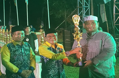 Pj. Sekretaris Daerah Kotabaru, Khairul Aswandi, menyerahkan piala kepada Kecamatan Pulau Laut Utara sebagai juara umum MTQ Nasional ke-55 tingkat Kabupaten Kotabaru