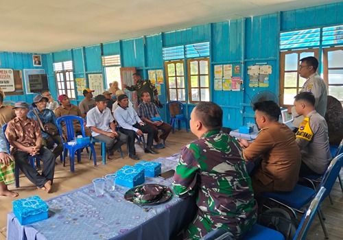 Satgas TNI dan Polri sedang memberikan sosialisasi kepada warga di dalam balai desa talusi