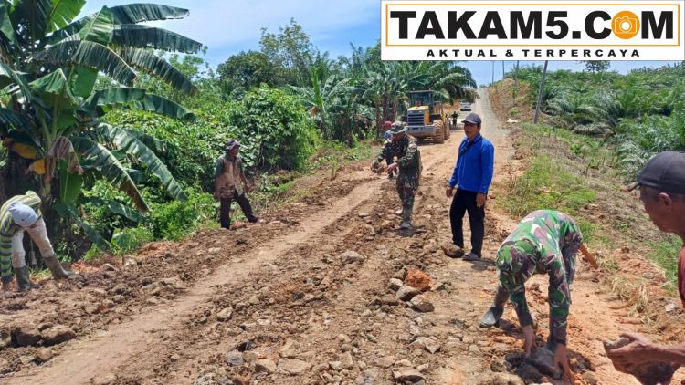 Personel TNI bersama warga Desa Talusi bergotong royong melakukan pengerasan jalan dalam program TMMD ke-123.