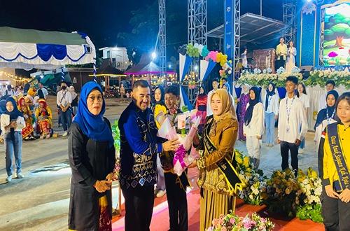 Suci Anisa Rusli menerima buket bunga dalam prosesi pengukuhan sebagai Bunda Forum Anak Daerah Kotabaru pada peringatan Hari Anak Nasional 2025 di Panggung Akrab Siring Laut.