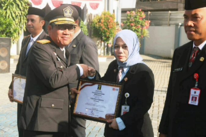 Pejabat Kanwil Kemenkumham Kalsel menyerahkan penghargaan kepada perwakilan penerima dalam upacara peringatan Hari Pengayoman ke-80 di Banjarmasin.