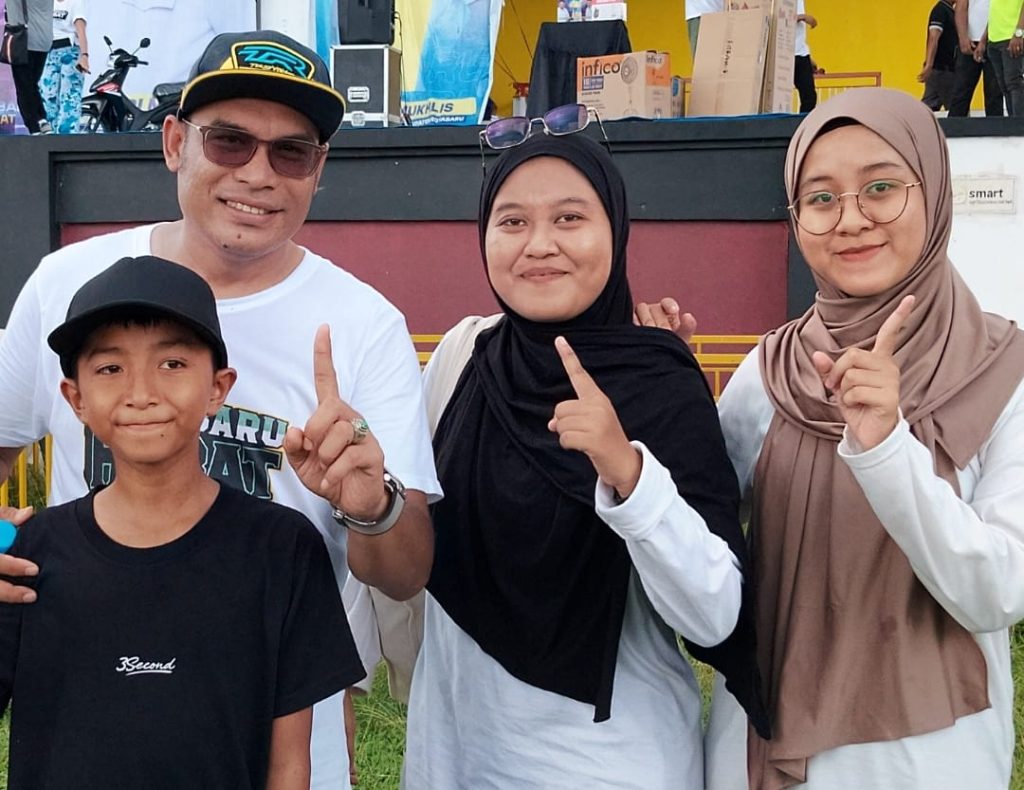 Wakil Bupati Kotabaru berfoto bersama Mardhatillah yang berkerudung coklat, kakaknya berkerudung hitam, dan adiknya mengenakan kaus hitam.