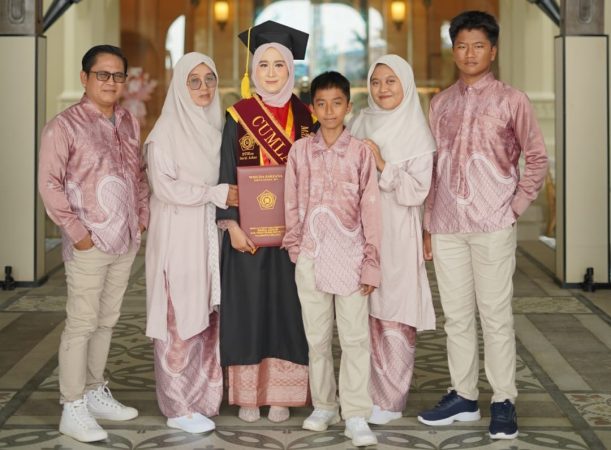 Mardhatillah mengenakan toga wisuda berfoto bersama keluarga.