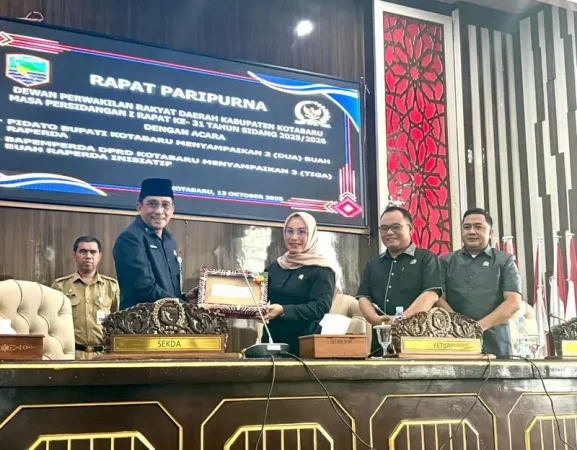 Asisten Administrasi Umum Setda Kotabaru, Slamet Riyadi, menyerahkan berkas Raperda kepada Ketua DPRD Kotabaru, Suwanti, dalam rapat paripurna di ruang sidang utama DPRD Kotabaru.