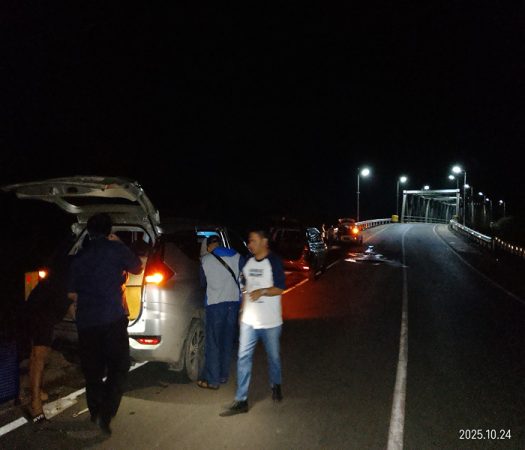 Sejumlah pengendara berhenti di jalan alternatif Tanah Bumbu–Banjarbaru setelah mobil mereka mengalami pecah ban akibat lubang besar di badan jalan, tepat sebelum jembatan besi perbatasan Tanah Bumbu, Jumat malam (24/10/2025). Foto Dok: Takam5.com