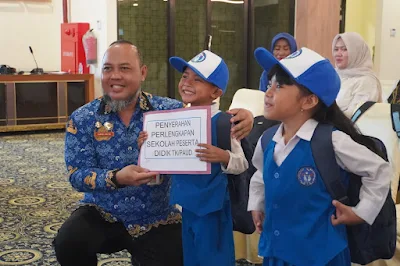 Pejabat Kotabaru menyerahkan perlengkapan sekolah kepada dua anak PAUD.