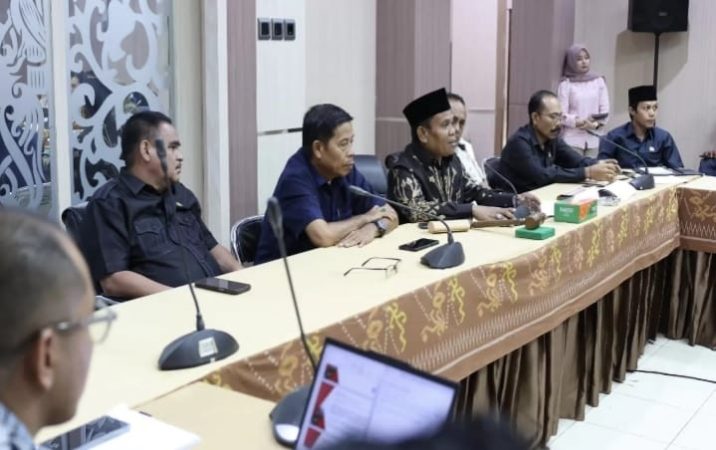 Sejumlah anggota DPRD duduk di meja rapat memimpin pertemuan bersama pihak perusahaan dan perwakilan pekerja di ruang rapat resmi.