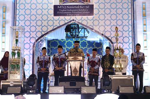Pejabat daerah menyampaikan sambutan pada penutupan MTQ ke-56 Kabupaten Kotabaru di panggung utama dengan latar ornamen islami dan piala juara.