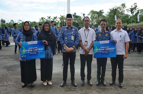 Sekda Kotabaru bersama perwakilan Bank Kalsel berfoto dengan ASN penerima hadiah umrah dan sepeda listrik usai apel gabungan di halaman Kantor Bupati Kotabaru.